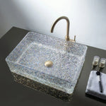 Decorative glass sink with gold faucet on a dark surface