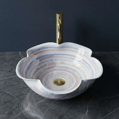 Decorative sink with a gold faucet on a dark surface
