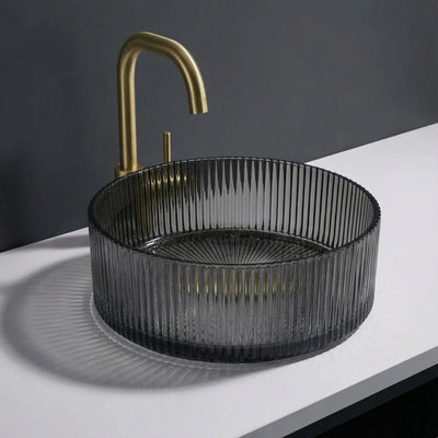 Black ribbed sink with gold faucet on a white countertop against a dark background