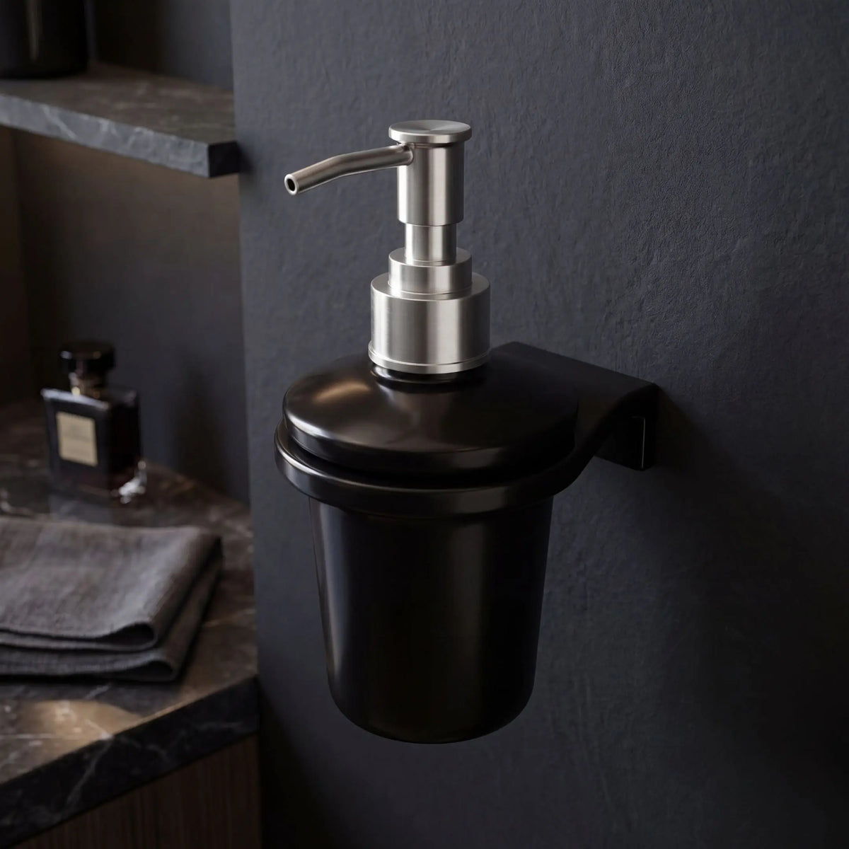Black soap dispenser with silver pump on a dark wall in a bathroom setting.