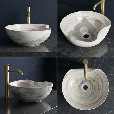 Multicolored round sink with gold faucet on a dark marble surface