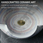 Handcrafted ceramic art piece with a rich glazed surface on a dark background