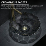 Glass sink with crown-cut facets on a dark surface