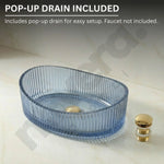 Blue glass sink basin with gold pop-up drain on a light background