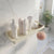 Bathroom shelf with skincare products and a plant in a modern bathroom setting