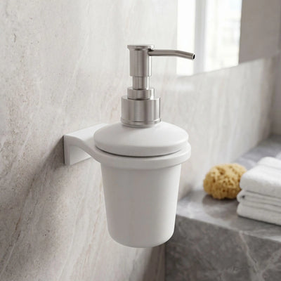 White soap dispenser with silver pump on a bathroom wall