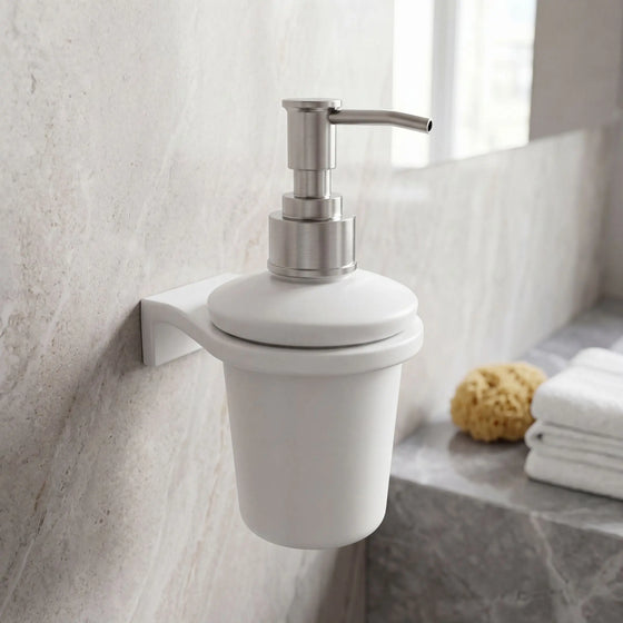 White soap dispenser with silver pump on a bathroom wall