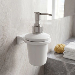 White soap dispenser with silver pump on a bathroom wall