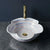 Decorative sink with a gold faucet on a dark surface