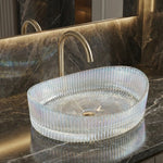 Glass sink on a marble countertop with a gold faucet