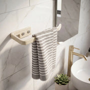 Striped towel hanging on a wooden towel rack in a bathroom with a sink and plant.
