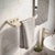 Striped towel hanging on a wooden towel rack in a bathroom with a sink and plant.