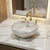 Decorative sink with artistic patterns on a marble countertop with gold fixtures.