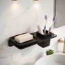 Bathroom shelf with soap, toothbrushes, and a plant on a marble wall.