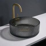 Black ribbed sink with gold faucet on a white countertop against a dark background