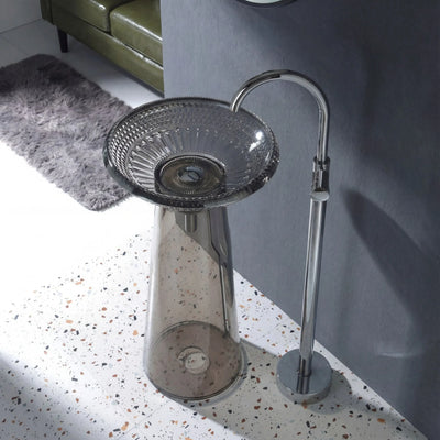 Modern freestanding bathtub with glass bowl and chrome faucet in a bathroom setting.