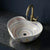 Multicolored sink with a gold faucet on a dark marble countertop