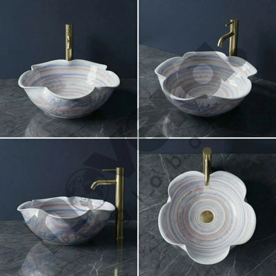 Marble-patterned sink with gold faucet on a dark surface