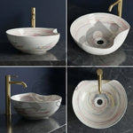 Multicolored round sink with gold faucet on a dark marble surface