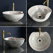 Multicolored round sink with gold faucet on a dark marble surface