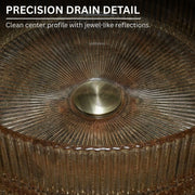 Close-up of a metallic drain with textured rim and central circular feature.