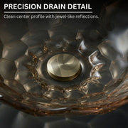 Close-up of a glass bowl with geometric design and reflections on a dark background.