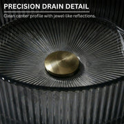 Close-up of a precision drain detail with a gold center and textured black surface.