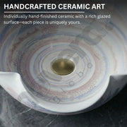Handcrafted ceramic art piece with a rich glazed surface on a dark background
