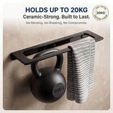 Black towel rack holding a kettlebell and towel on a beige wall.