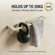 Wall-mounted rack holding a kettlebell and towel with text about weight capacity and durability.