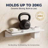 White shelf with a black kettlebell labeled '20KG' on a beige marble background, emphasizing durability.