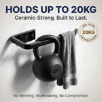 Black kettlebell with towel on a white background, featuring text about weight capacity and durability.