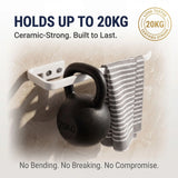 Wall-mounted hook holding a kettlebell with text about its capacity and features.