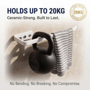 Wall-mounted hook holding a kettlebell with text about its capacity and features.
