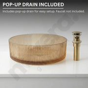 Glass sink basin with gold pop-up drain on a white background