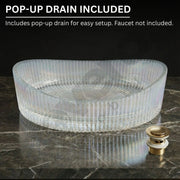 Clear glass sink basin with pop-up drain on a dark marble surface