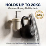Black kettlebell with '20KG' marking on a white wall with text about weight capacity and durability.