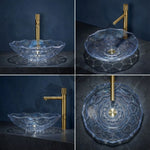 Clear glass sink with gold faucet on a dark background