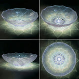 Four views of a decorative glass bowl with geometric patterns on a dark background
