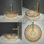 Glass sink with gold faucet on a gray background