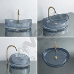 Blue glass sink with gold faucet on a gray surface