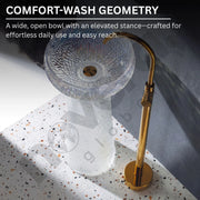 Clear glass sink with gold faucet on a speckled countertop